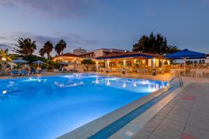 a large swimming pool with a hotel in the background at Hotel Tigaki's Star in Tigaki