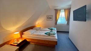 mała sypialnia z łóżkiem i oknem w obiekcie THERMEN - APARTMENT BIODORF Bad Waltersdorf w mieście Bad Waltersdorf
