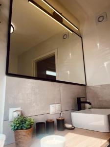 uma casa de banho com um lavatório e um espelho grande em Domek u Gajka Słajszewo em Słajszewo