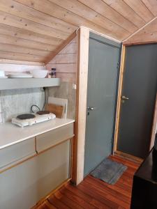 une petite cuisine avec une porte menant à une chambre dans l'établissement Kvamshaugen hytter, à Luster