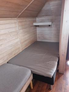 a bed in a small room with wooden walls at Kvamshaugen hytter in Luster