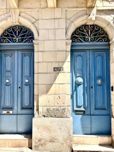 twee blauwe deuren aan de zijkant van een gebouw bij lovely apartment close to the sea in Il-Gżira