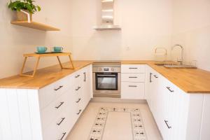 a kitchen with white cabinets and a sink and a stove at Mãe - Casas de Selim in Arcos de Valdevez