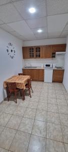 a kitchen with a wooden table and a tableasteryasteryasteryasteryasteryasteryastery at Apartman Afrodita 1 in Bardejovské Kúpele