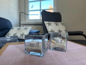 two glass vases with candles on a table at Schmucke-Huus-Appartement-2 in Westerland