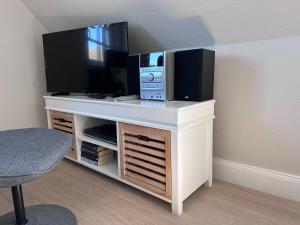 a entertainment center with a flat screen tv on top of it at Schmucke-Huus-Appartement-2 in Westerland +7 photos