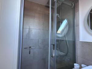 a shower with a glass door in a bathroom at Schmucke-Huus-Appartement-2 in Westerland