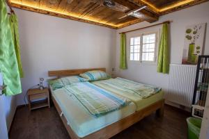 um quarto com uma cama com cortinas verdes e uma janela em WIEDNERMICHL - Urlaub in den Weinbergen em Krottendorf bei Ligist