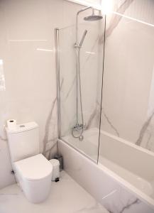 a white bathroom with a shower and a toilet at Altiva - Casas de Selim in Arcos de Valdevez