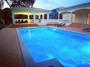 a swimming pool in front of a house at Magellan House in Vilamoura