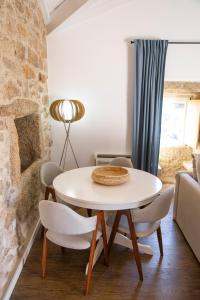 a dining room with a white table and chairs at Primitiva - Casas de Selim in Arcos de Valdevez