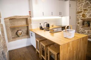 a kitchen with a wooden island in a room at Primitiva - Casas de Selim in Arcos de Valdevez +15 photos