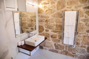 a bathroom with a sink and a stone wall at Altiva - Casas de Selim in Arcos de Valdevez