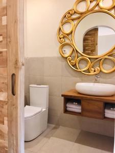 a bathroom with a mirror and a toilet and a sink at Belaya Hotel in Jepara