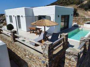 Deja blue villa 2 في Agios Georgios: فيلا بمسبح وفناء فيه مظلة