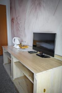 a wooden desk with a television on top of it at Willa Centrum in Supraśl