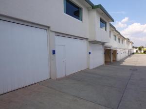 una fila di porte bianche del garage su un edificio di GS Cuernavaca Drive Inn - Adults Only a Cuernavaca