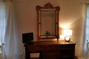 a mirror and a television on a dresser in a room at Le Pigeonnier in Vaison-la-Romaine