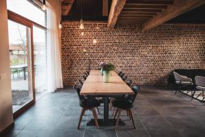 uma sala de jantar com mesa e cadeiras e uma parede de tijolos em Sint-Jacobshoeve 3 em Oudenaarde