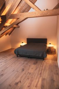 a bedroom with a bed and wooden floors at Sint-Jacobshoeve 3 in Oudenaarde