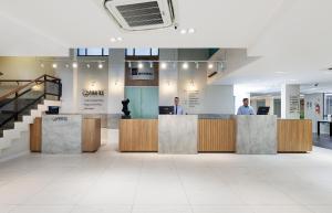 a lobby with two men standing at a reception desk at Miramar Hotel in Balneário Camboriú