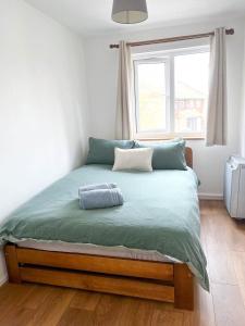 a bedroom with a large bed with a window at Lovely 2 bedroom flat with free parking, great transport links to Central London, the Excel Centre, Canary Wharf and the O2! in London