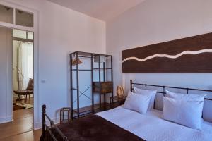 um quarto com uma cama grande e almofadas brancas em The Blue Sky Nest em Lisboa