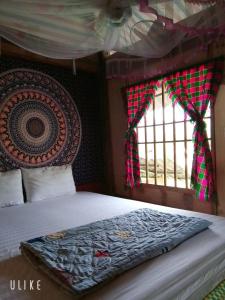 a bedroom with a bed and a window at Du Già Vân Chung Homestay in Làng Cac