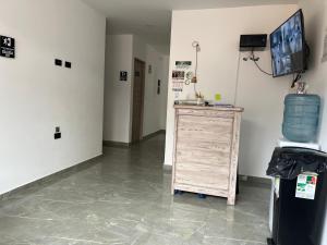 a room with a wooden dresser and a television on a wall at HOTEL BLUE GUATAPE in Guatapé