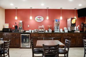 um restaurante com uma mesa e cadeiras e uma parede vermelha em Super 8 by Wyndham Jackson em Jackson