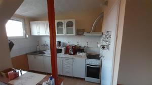 una piccola cucina con armadietti e elettrodomestici bianchi di Bujdy Apartman a Szerencs