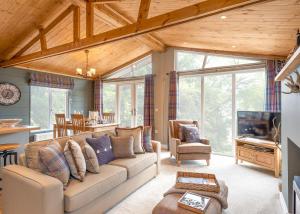a living room with a couch and a tv at Thirlestane Woodland Lodges in Lauder
