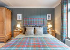 a bedroom with a large bed and two night stands at Thirlestane Woodland Lodges in Lauder