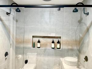 a bathroom with three bottles of wine on a shelf at Mountain Cottage in Dandenong Ranges in Mount Dandenong
