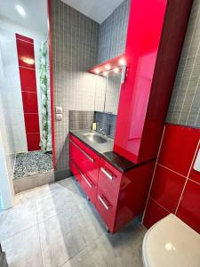 baño rojo con lavabo y ducha en Le Khoros - Proche plage, en La Rochelle