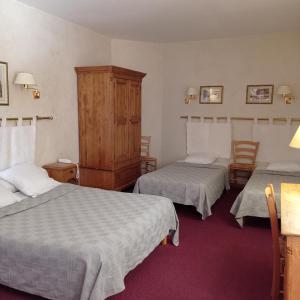 une chambre d'hôtel avec deux lits et une armoire dans l'établissement Hôtel Saint Jean, à Orange