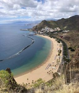 uma vista para uma praia com pessoas e para o oceano em Cozy room near Las Teresitas beach em Santa Cruz de Tenerife