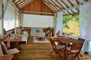 Nathylodge في بوكاس تاون: غرفة معيشة مع طاولات وكراسي وأريكة