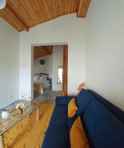 ein blaues Sofa im Wohnzimmer mit einem Bett in der Unterkunft Quinta da Choupana in Tomar