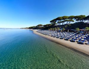 an empty beach with lounge chairs and the ocean at Hotel Giardino in Follonica