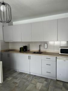 una cocina con armarios blancos y fregadero en Apartamento 70 Vera Playa en Vera