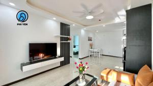 a living room with a fireplace and a tv at Phi Yen Muong Thanh 04 Apartment in Nha Trang
