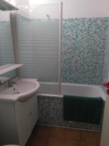 een badkamer met een bad, een wastafel en een bad bij Parc des Salins in Hyères
