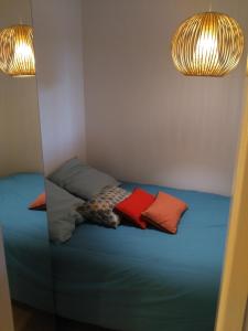 een bed met 2 kussens in een kamer met 2 verlichting bij Parc des Salins in Hyères