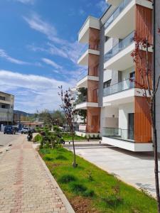 an apartment building with a sidewalk next to a street at Solar Rooms and Apartments in Himare