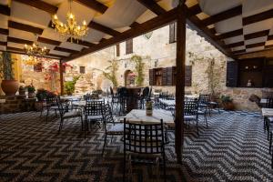 a dining room with tables and chairs and a chandelier at APRIL Luxury Suites in Rhodes Town