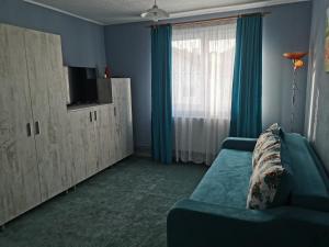 ein Wohnzimmer mit einem Sofa und einem großen Fenster in der Unterkunft Apartament Ramona in Zărneşti