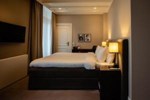 une chambre d'hôtel avec un lit et une télévision dans l'établissement Villa de Duinen - Adults Only, à Noordwijk aan Zee