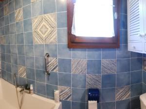 a bathroom with blue tiles and a window and a tub at Chalet Samoëns, 5 pièces, 8 personnes - FR-1-629-103 in Samoëns