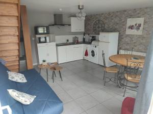 eine Küche und ein Esszimmer mit einem Tisch und Stühlen in der Unterkunft Claude et Astrid in Tour-en-Bessin